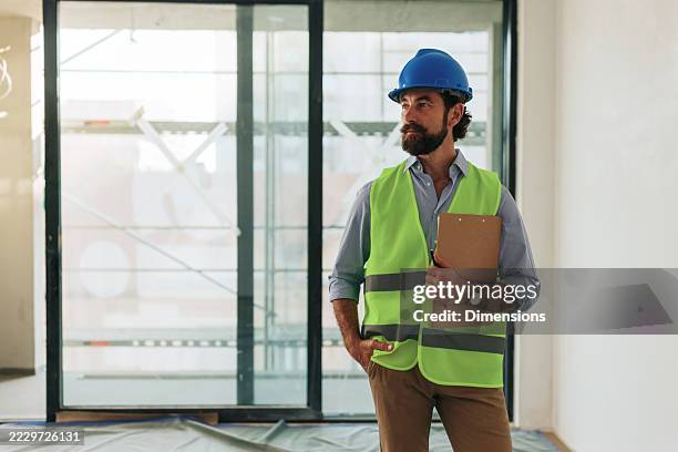 construction engineer inspecting building site with clipboard - construction clipboard stock pictures, royalty-free photos & images