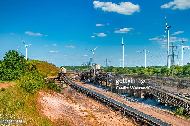 opencast mine garzweiler ii with conveyor belts and wind turbines in the background - mina abierta fotografías e imágenes de stock