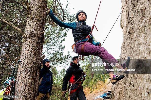 climber friends practicing outdoor climbing with safety gear - abseiling stock pictures, royalty-free photos & images