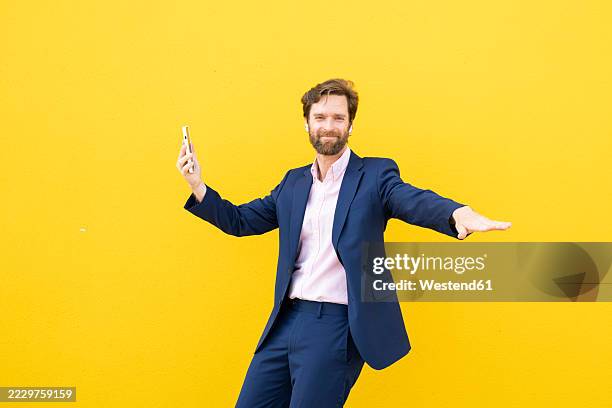 businessman dancing outdoors with yellow background - couleur de fond photos et images de collection