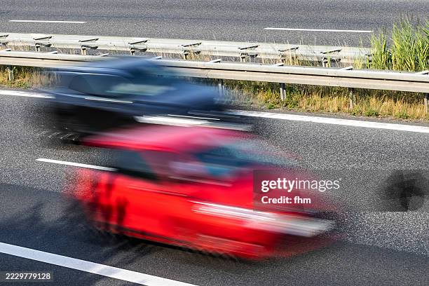 two very fast overtaking cars on a country road - vorbeigehen stock-fotos und bilder