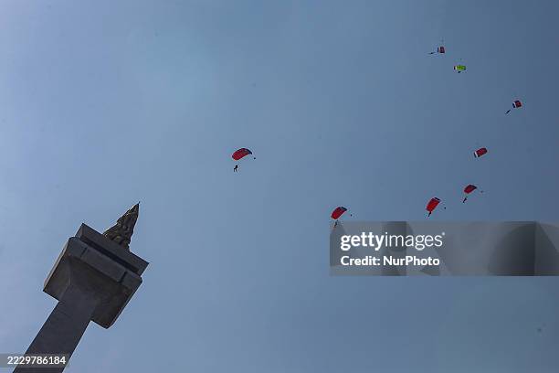 Indonesian Armed Forces soldiers perform a parachute jump at Indonesia's 80th Independence Day ceremony above the National Monument in Jakarta,...