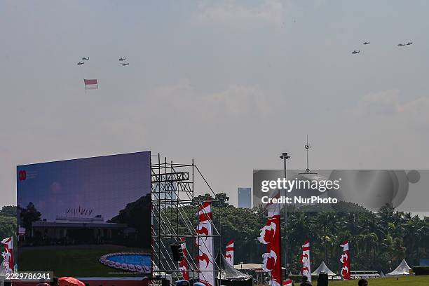 Indonesian Armed Forces helicopters unfurl the Indonesian flag during Indonesia's 80th Independence Day ceremony above the National Monument in...