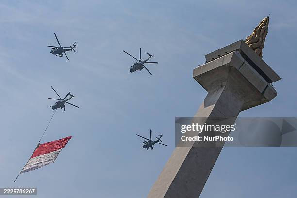Indonesian Armed Forces helicopters unfurl the Indonesian flag during Indonesia's 80th Independence Day ceremony above the National Monument in...