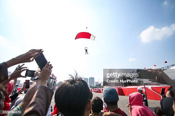 Indonesian Armed Forces soldiers perform a parachute jump at Indonesia's 80th Independence Day ceremony above the National Monument in Jakarta,...