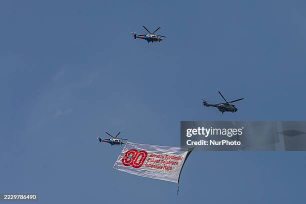 Indonesian Armed Forces helicopters unfurl the Indonesian flag during Indonesia's 80th Independence Day ceremony above the National Monument in...