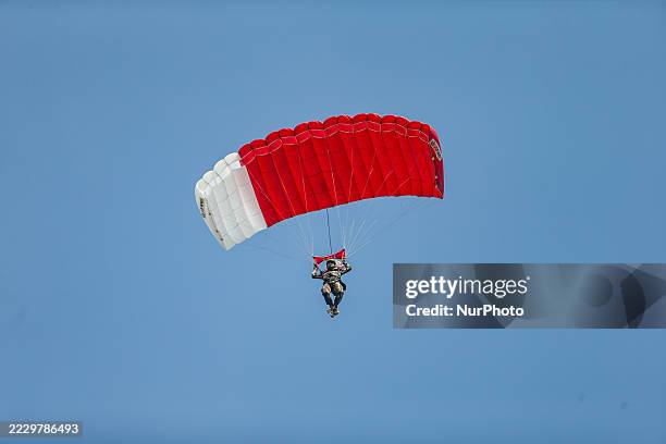 Indonesian Armed Forces soldiers perform a parachute jump at Indonesia's 80th Independence Day ceremony above the National Monument in Jakarta,...