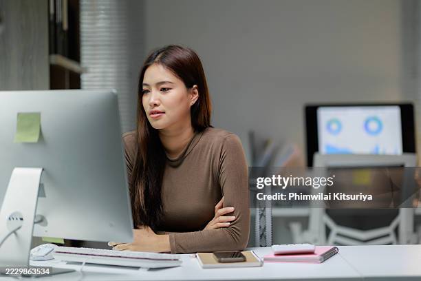 focused asian businesswoman working on computer in modern office - east asian ethnicity stock pictures, royalty-free photos & images