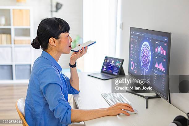 frau mit smartphone beim programmieren programm für künstliche intelligenz - data mining stock-fotos und bilder
