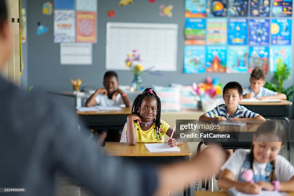 Diverse Elementary Classroom With Students Learning At Their Desks
