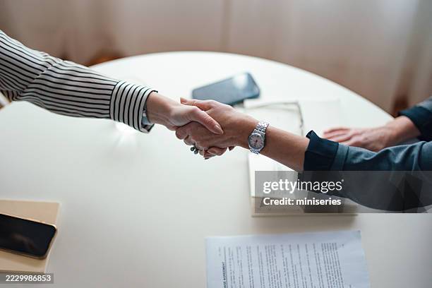 stretta di mano professionale a un tavolo d'ufficio durante una riunione di lavoro - autoaffermazione foto e immagini stock