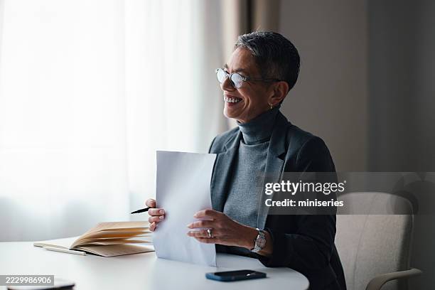 smiling professional discussing documents at a bright, modern office space - making choices stock pictures, royalty-free photos & images