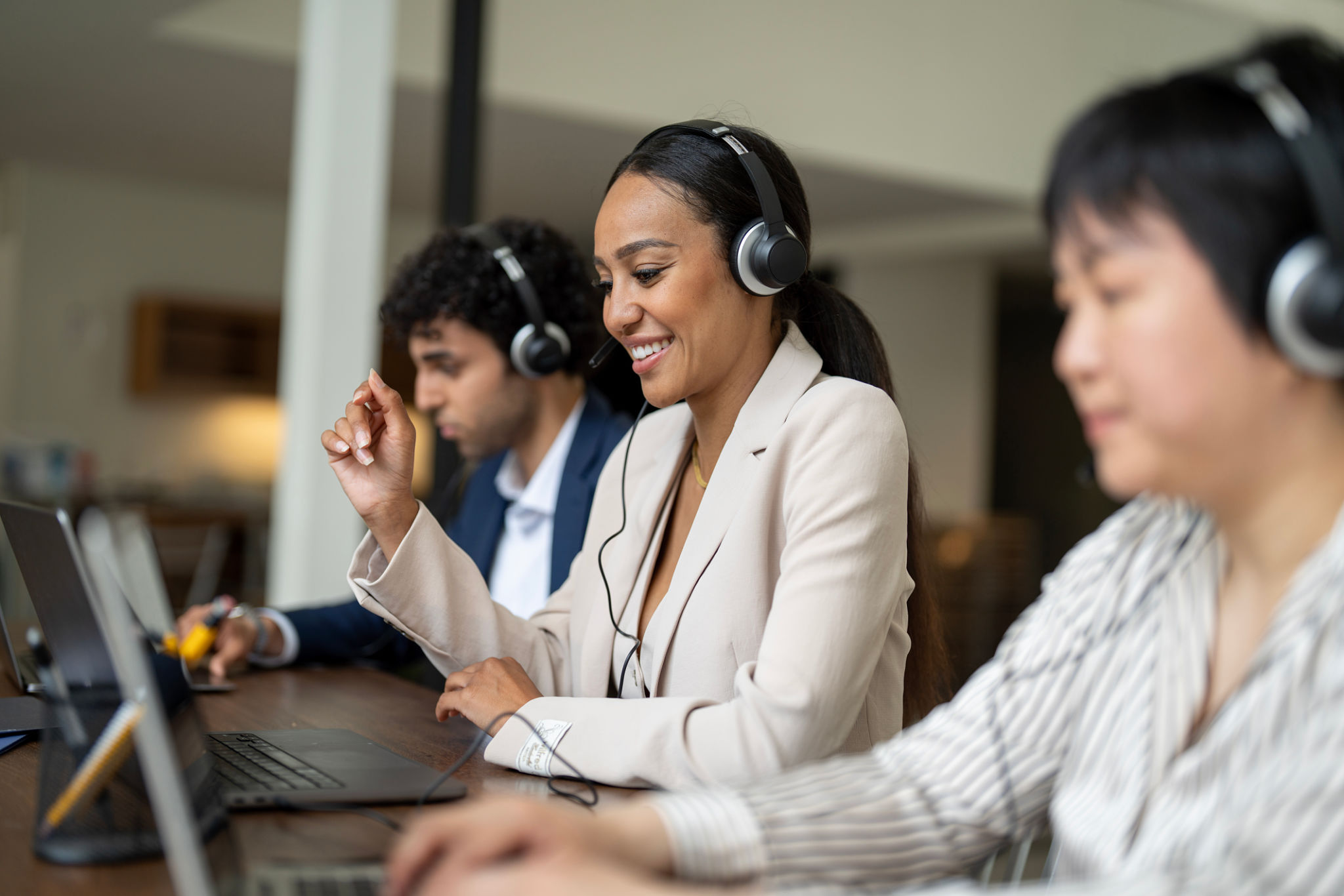 Professional team providing customer service through headsets in a collaborative workspace, emphasizing productivity and support services.
