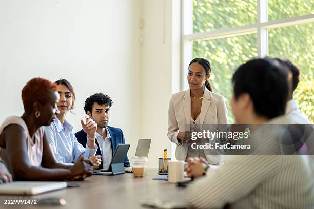team eterogeneo che collabora in un ufficio moderno per una riunione di lavoro produttiva - task force foto e immagini stock