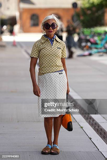 Grece Ghanem, attending the Herskind show during Copenhagen Fashion Week SS26, is seen wearing a yellow and black checkered short-sleeve polo shirt...