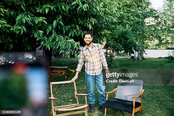 man restoring wooden furniture in backyard workshop with mobile phone and tools - personalization stock pictures, royalty-free photos & images