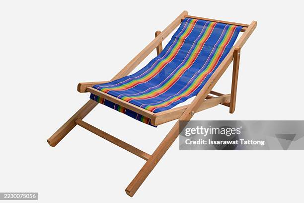 a blue and red striped beach chair with wooden legs - sedia da giardino foto e immagini stock