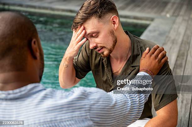 man receiving comfort by a poolside during an emotional moment - words of support and encouragement stock pictures, royalty-free photos & images