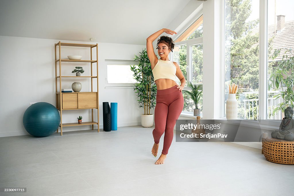 Woman Practicing Dance Exercise in Bright Home Yoga Studio