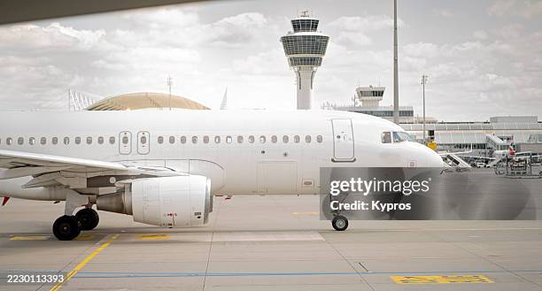 passenger jet on runway at munich airport - flughafen kontrollturm stock-fotos und bilder