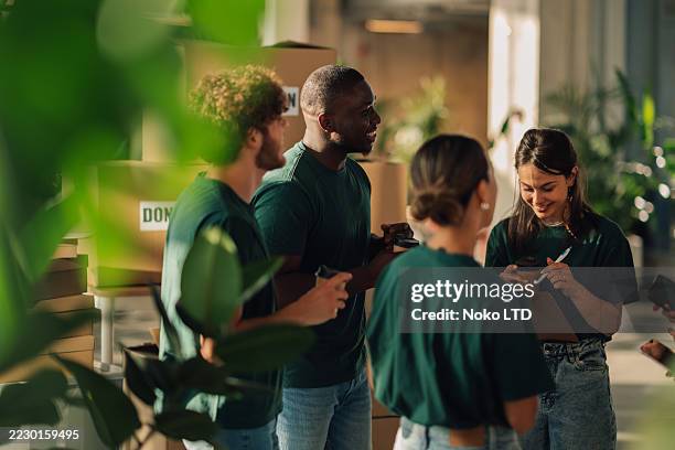volunteers preparing donation boxes at charity organization - non profit organization stock pictures, royalty-free photos & images