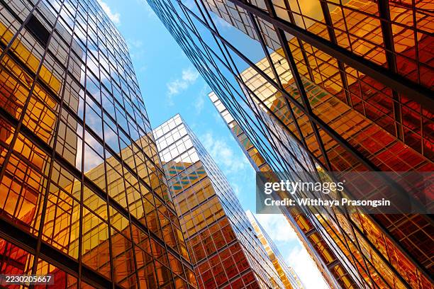modern skyscrapers reaching for the sky in a vibrant city - skyscraper stock pictures, royalty-free photos & images