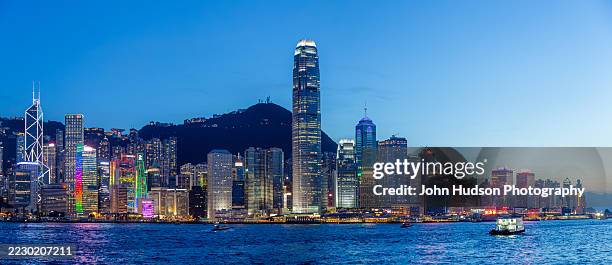 hong kong island skyline at dusk from kowloon - hongkong-eiland stockfoto's en -beelden