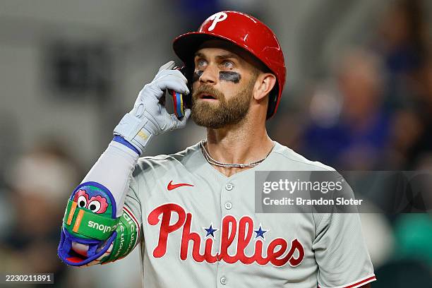 Bryce Harper of the Philadelphia Phillies adjusts his helmet in the fourth inning during a game against the Texas Rangers at Globe Life Field on...