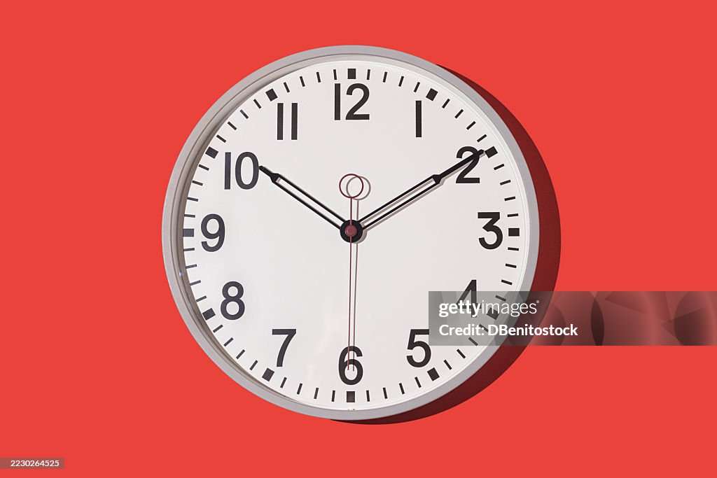 Wall clock showing 10:10 on a red background. Time, hour, minute, second, measuring instrument.