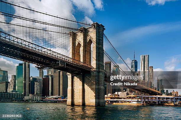 brooklyn bridge over east river with manhattan skyline in new york city - brooklyn bridge stockfoto's en -beelden