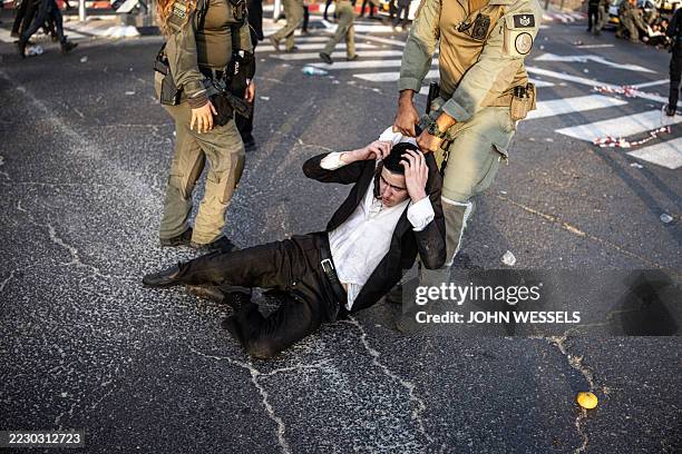 An Ultra-Orthodox Jewish man is dragged by Israeli security forces during a protest against Israeli army conscription in Kfar Yona on August 19,...