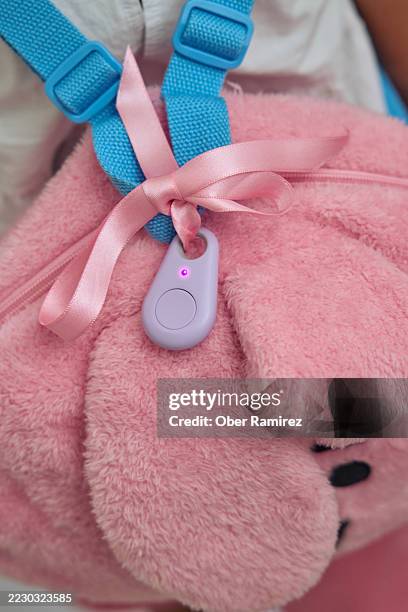 close up of a smart tracker attached to a girl's backpack - location tracking stock pictures, royalty-free photos & images