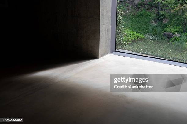 sunlight streaming through a glass window onto a concrete floor - light rays through window stock pictures, royalty-free photos & images