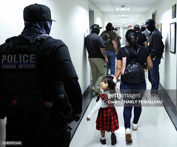 Woman and her child arrive at a hearing as federal agents patrol the hallways outside of a courtroom at New York Federal Plaza Immigration Court at...