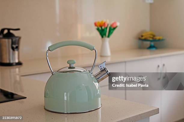 boiling kettle on kitchen table - theepot stockfoto's en -beelden
