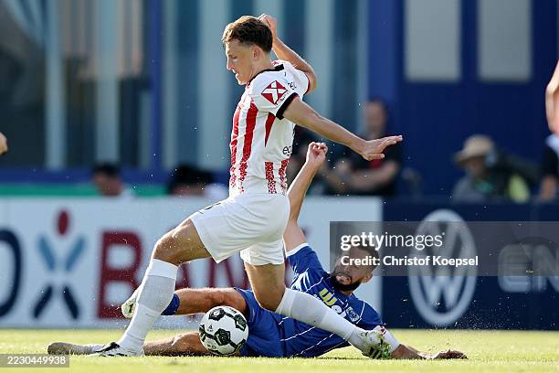 Kamer Krasniqi of Sportfreunde Lotte challenges Maximilian Eggestein of SC Freiburg during the DFB Cup match between VfL Sportfreunde Lotte and...