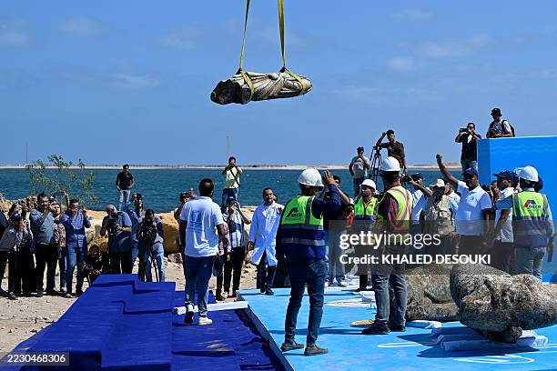 Crane pulls an artifact from the waters at Abu Qir bay in Alexandria on August 21 as part of an event organized by the Ministry of Tourism and...