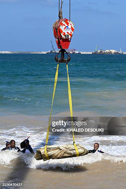 Crane pulls an artifact from the waters at Abu Qir bay in Alexandria on August 21 as part of an event organized by the Ministry of Tourism and...