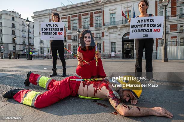 Animal rights activists of PETA performing a protest outside the Madrid regional government headquarters under the slogan "Firefighters yes,...