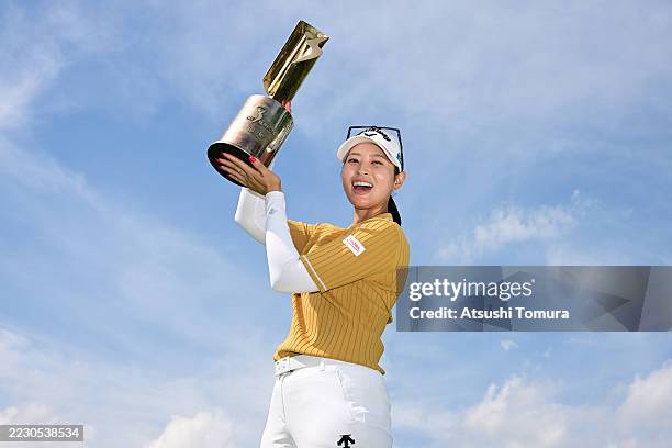 Asuka Kashiwabara of Japan poses with the trophy after winning the tournament on the 18th green following the final round of NEC KARUIZAWA72 GOLF...