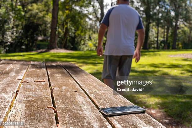 middle aged man walking away without his phone - lost stock pictures, royalty-free photos & images
