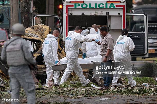 Police officers carry the body of a victim of a bomb explosion in Cali, Colombia on August 21 2025. Five people were killed and dozens were injured...