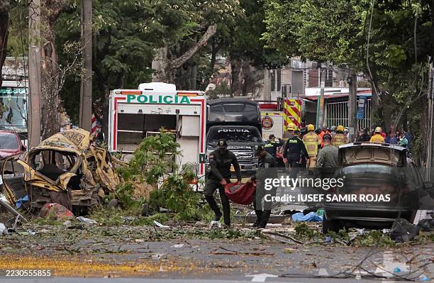 Police officers carry debris from the site of a bomb explosion in Cali, Colombia on August 21 2025. Five people were killed and dozens were injured...