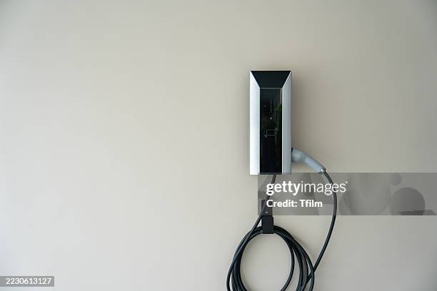 a black and silver charging station is mounted on a wall - chargeur de batterie photos et images de collection