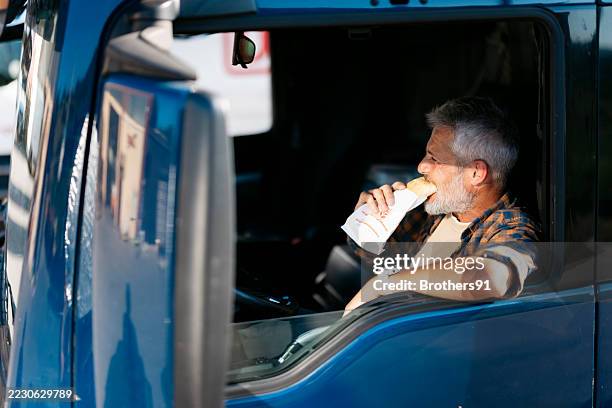 truck driver eating sandwich during lunch break inside cabin - passenger cabin stock pictures, royalty-free photos & images