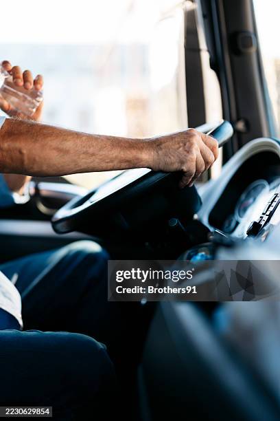 truck driver drinking water while driving on the road - hands steering wheel stock pictures, royalty-free photos & images