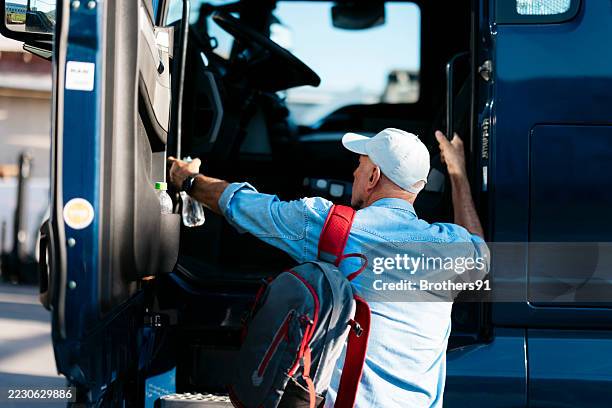 camionista che lascia il suo camion per le consegne parcheggiato - entrare foto e immagini stock