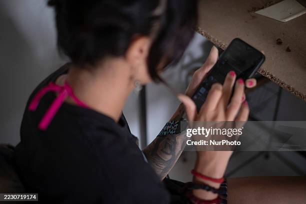 Mona Jalali a member of Generation Z, uses her smartphone as she works at a home-based workshop in southern Tehran, Iran, on August 17 where she...
