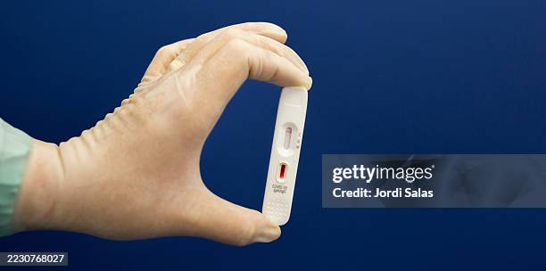 doctor holding positive covid-19 antigen rapid diagnostic test - lateral flow test stock pictures, royalty-free photos & images