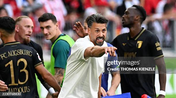 Augsburg's German head coach Sandro Wagner reacts as his players celebrate their third goal during the German first division Bundesliga football...